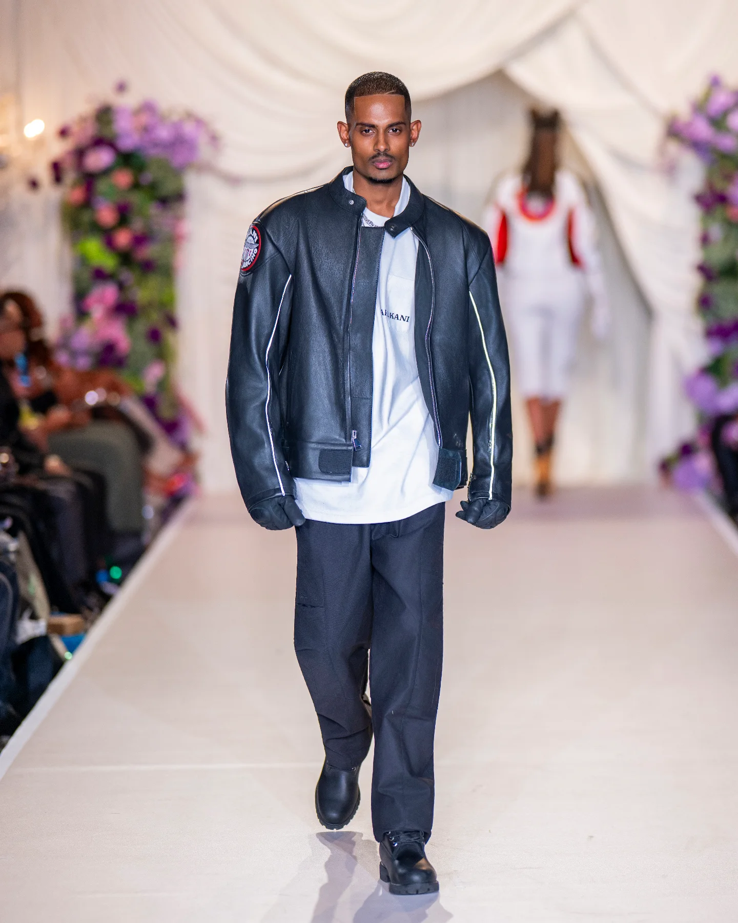 NIJO walking the Emerge! Show runway for Karl Kani — KK Racing leather jacket