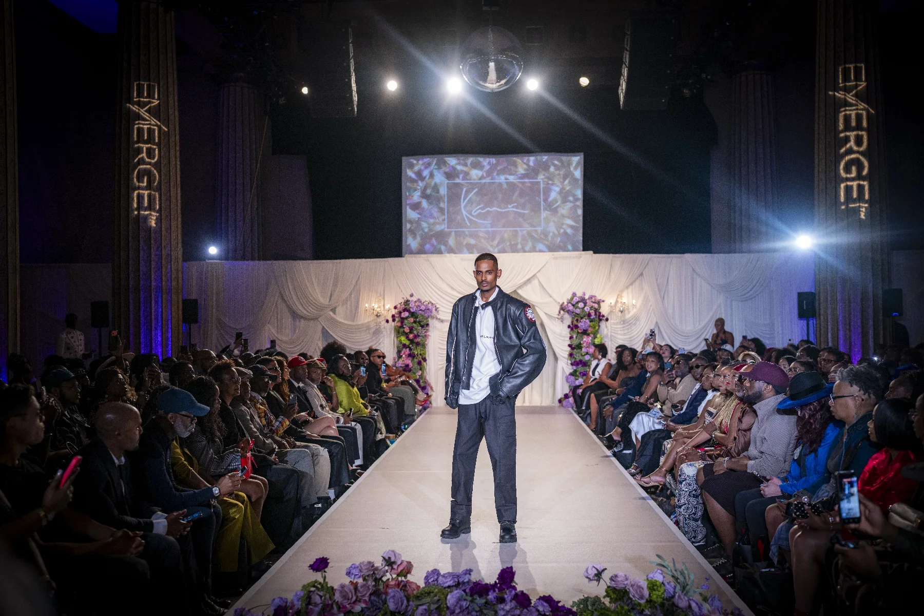 NIJO on the Karl Kani runway at the Emerge! Show, New York Fashion Week 2026 — Kani logo on screen, full house on both sides