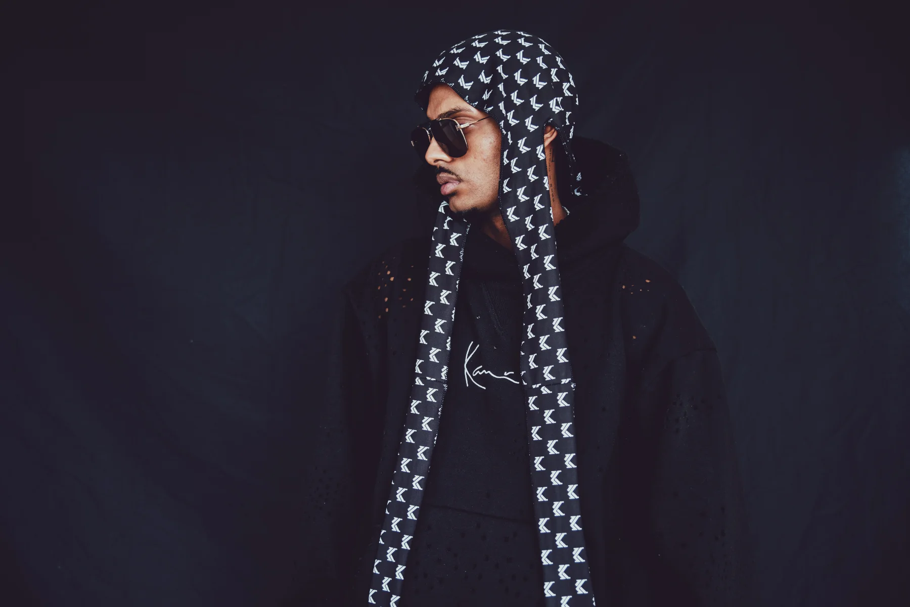 NIJO head turn — Karl Kani durag with all-over K print, black perforated Kani hoodie