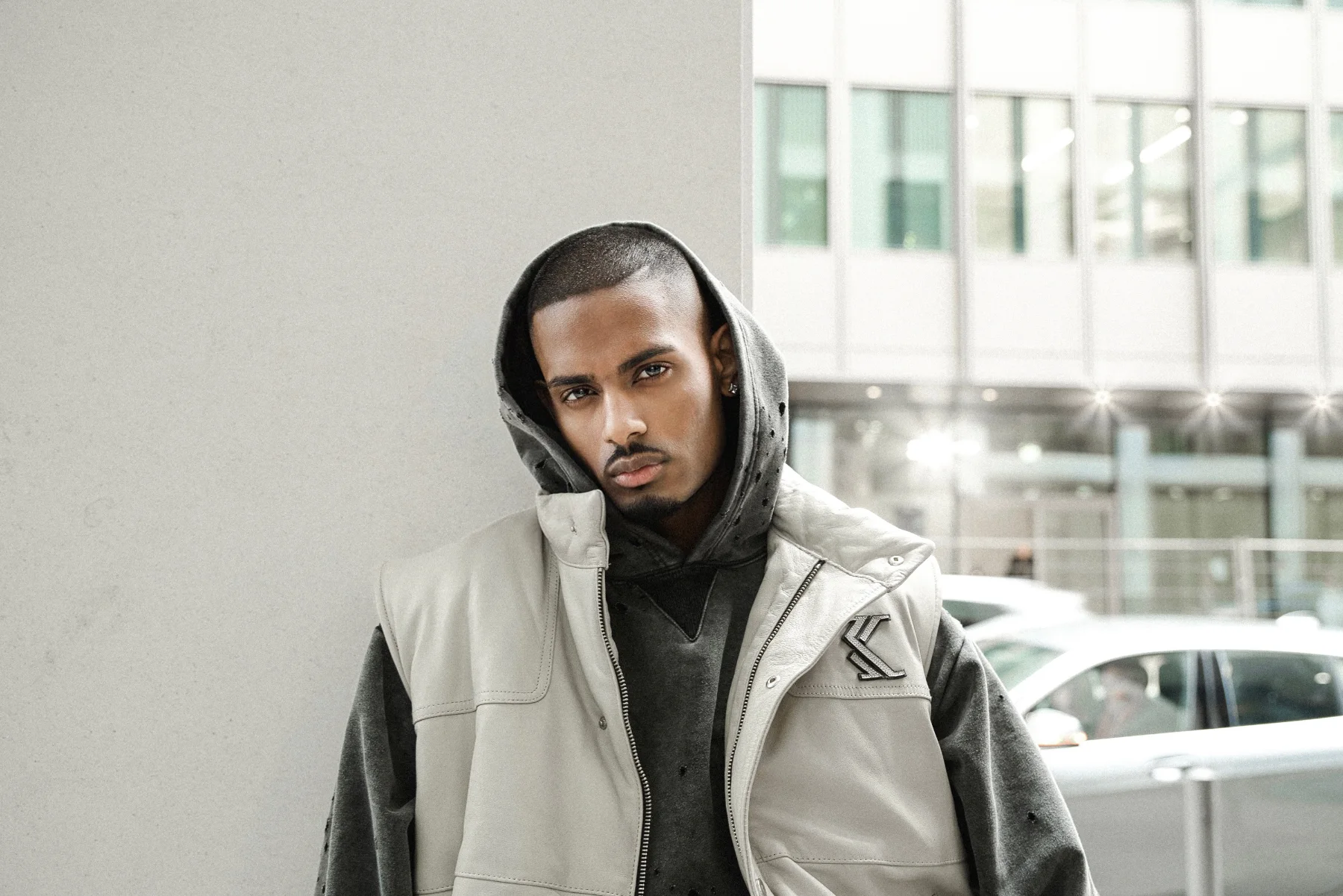 NIJO leaning, leather puffer vest, hooded, white concrete plaza